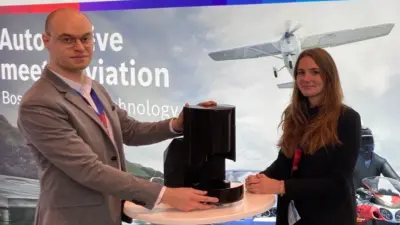 Picture of two colleagues in front of the Bosch banner with our Hardware Device